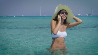 Güzel bir kadın cep telefonuyla konuşuyor. 