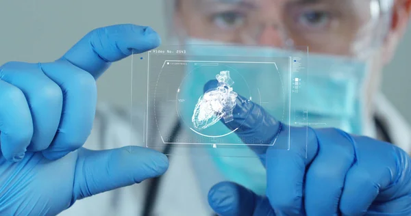 A doctor looks at a sheet of a patient and the analyzes so futuristic thanks to augmented reality and holography technology. Concept: medicine, future, immersive technology, doctor