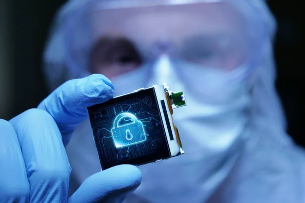 在超现代电子制造工厂设计工程师无菌整体持有微芯片符号在未来主义全息术 网络安全系统 — 图库照片
