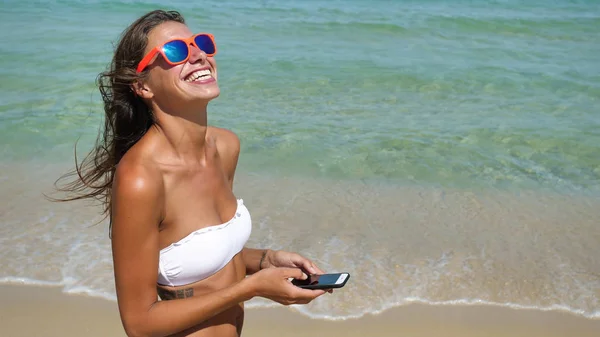 Красива Дівчина Щасливо Сміється Пише Повідомлення Телефону Морі Сонцезахисних Окулярах — стокове фото