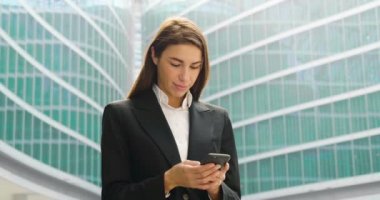 iş kadını ceketli modern cam binasında cep telefonu açık havada tarama video 