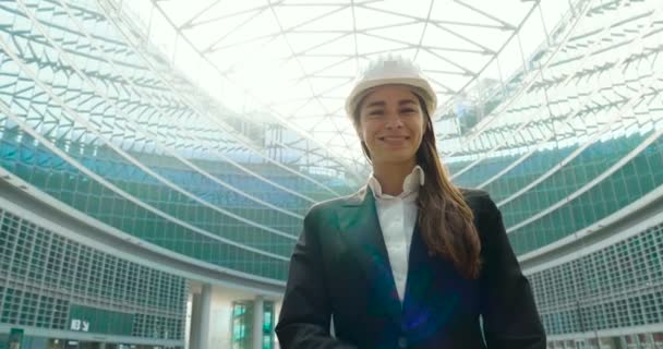 近代的なオフィス ガラスの白い建物のヘルメットと建物の屋外でのビジネス女性のスロー モーション ビデオ — ストック動画