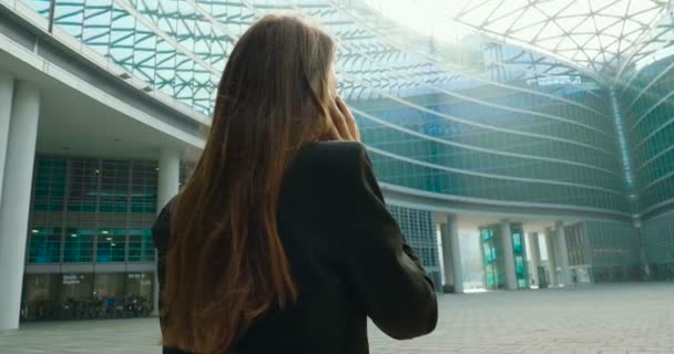 在现代玻璃建筑的户外手机上 穿着全套西装的女子谈话视频 — 图库视频影像