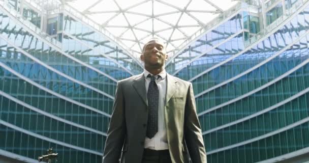 モダンなガラスの建物 スローモーション映像で成功する幸せなアフリカ ビジネス人 — ストック動画