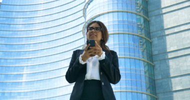 cep telefonu açık havada modern cam binasında tarama iş kadını ağır çekim video 
