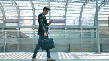 Bir takım, genç yakışıklı işadamı (öğrenci) istasyonunda, havaalanında bir evrak çantası ile birlikte gelir. Konsept: bir yeni iş seyahat dünya, iletişim, kişiler, yeni anlaşma, başarı,.