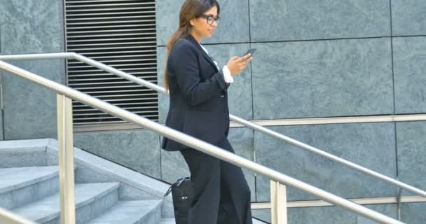 Video Businesswoman Browsing Mobile Phone Carrying Bag Walking Stairs — Stock Video