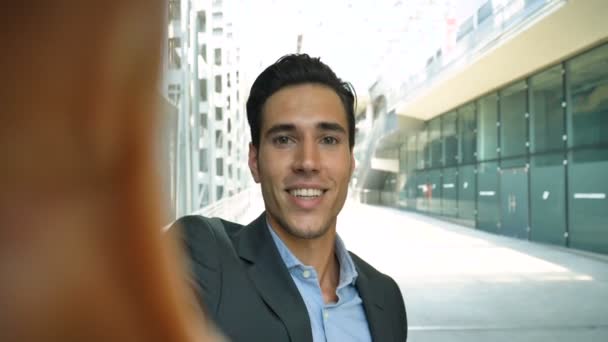 一个年轻的英俊商人 的肖像 在西装 面带微笑 视频电话 在车站 在机场 新业务 周游世界 — 图库视频影像