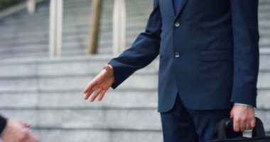 Şehir iki işadamı onlar el sıkışın ve bir proje üzerinde birlikte çalışmak başlamadan önce gülümse. Konsept: ekip çalışması, iş, sözleşme, banka.