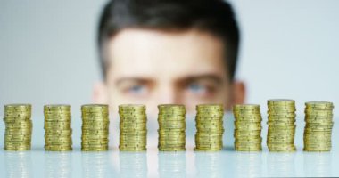 Bir işadamı bir takım elbise ve kravat onu daha önce birçok altın sikke yığını var. İşadamı sayar ve parayı dikkatli izle. Konsept: yatırım bankaları, borsa, emeklilik ve özel kredi.