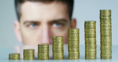 Bir işadamı bir takım elbise ve kravat onu daha önce birçok altın sikke yığını var. İşadamı sayar ve parayı dikkatli izle. Konsept: yatırım bankaları, borsa, emeklilik ve özel kredi.