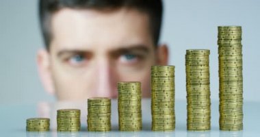 Bir işadamı bir takım elbise ve kravat onu daha önce birçok altın sikke yığını var. İşadamı sayar ve parayı dikkatli izle. Konsept: yatırım bankaları, borsa, emeklilik ve özel kredi.