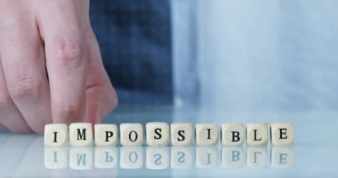 küçük geometrik küpleri mektuplar, küpleri kelime imkansız ile hareket kişinin kısmi görünümü ile video 