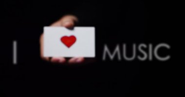 müziği çok seviyorum mesaj ile küçük kağıt kartı gösteren el video, kısmi görünümünü