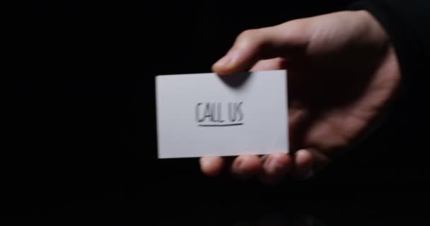 小さな紙メッセージ カードを示す手のビデオ 部分的なビューは 私たちを呼び出す — ストック動画
