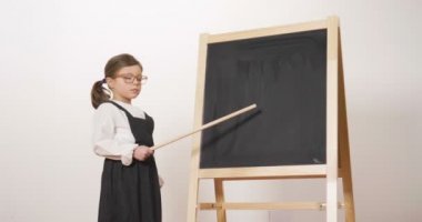 Küçük bir karatahta önünde bir öğretmen kollarındaki katlanmış ve gülümsüyor tutar olarak mutlu bir kız kılığında. Kavramı: eğitim, okul, iş ve çalışma için aşk.