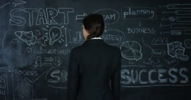 Güzel kız öğretmen, pazarlama, siyah bir arka plan üzerinde siyah bir tahta üzerinde başarı grafiğini çizer. Konsept: kariyer büyüme, büyüme grafiği, başarılı kız, pazarlama, fikirler, mali.