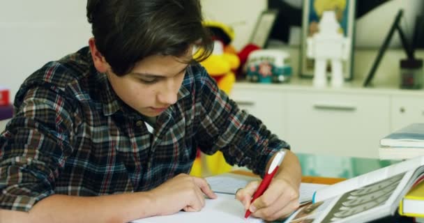 年轻学生男孩在桌子上学习 写家庭任务的视频 — 图库视频影像