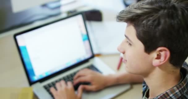 年轻学生男孩在桌子上学习 使用笔记本电脑和看着相机的视频 — 图库视频影像