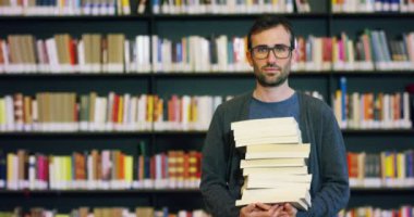 Mutlu ve kaygısız bir kitaplıkta kitap okuma genç bir öğrenci. Konsept: eğitim, portre, Kütüphane ve çalışkan, sakin ol.