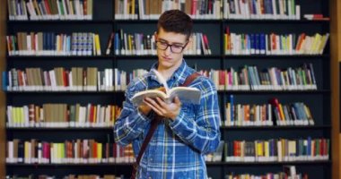 Mutlu ve kaygısız bir kitaplıkta kitap okuma genç bir öğrenci. Konsept: eğitim, portre, Kütüphane ve çalışkan, sakin ol.