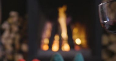 Soğuk sonbahar ya da kış akşam. İnsanlar ateşin yanında battaniye ve çay ile dinlenme. Yün çorap ayaklarda closeup fotoğraf. Sıcak sahne.