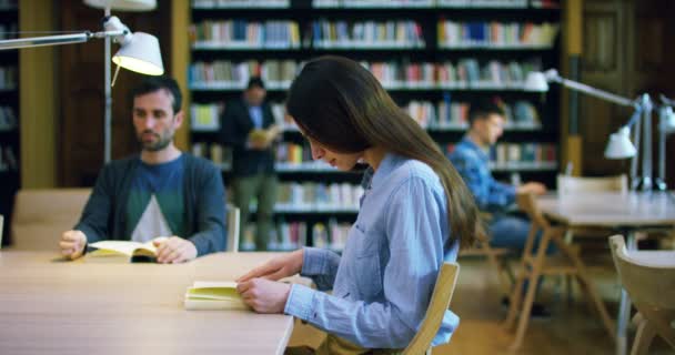 若い学生は 本を読んで幸せ のんきな図書館で勉強します 肖像画 ライブラリ そして 熱心なリラックス — ストック動画