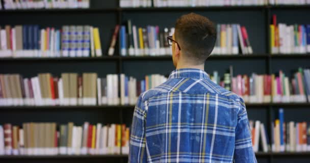 Ein Junger Student Der Einer Fröhlichen Und Unbeschwerten Bibliothek Studiert — Stockvideo