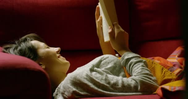 Video Einer Frau Auf Dem Sofa Beim Lesen Eines Buches — Stockvideo