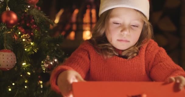 Vídeo Linda Menina Abrindo Caixa Presente Árvore Natal — Vídeo de Stock