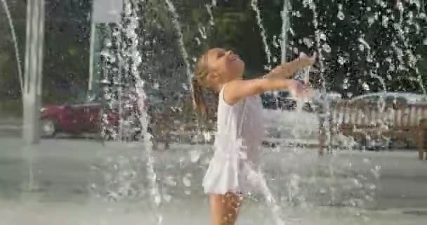 二人の少女を楽しんで 透明な水の背景に白いドレスを着て笑顔 噴水で遊ぶ — ストック動画