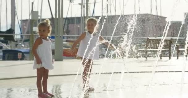 Duas Meninas Estão Divertindo Brincando Uma Fonte Sorrindo Vestidos Brancos — Vídeo de Stock