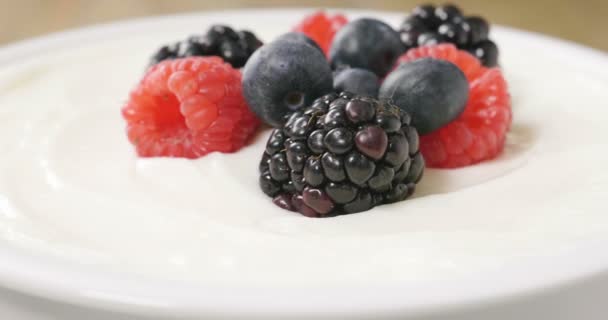 典型的な本物ヨーグルト ブルーベリー ラズベリー ブラックベリー ミューズリーの朝食の組成物 フィットネス ダイエット フィットネス — ストック動画