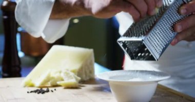 Aşçı rende Parmesan peyniri, ağır çekim, tipik İtalyan peyniri, Taze demlenmiş sadece tabakta. Konsept: İtalyan mutfağı, peynir, Restoran ve gıda.
