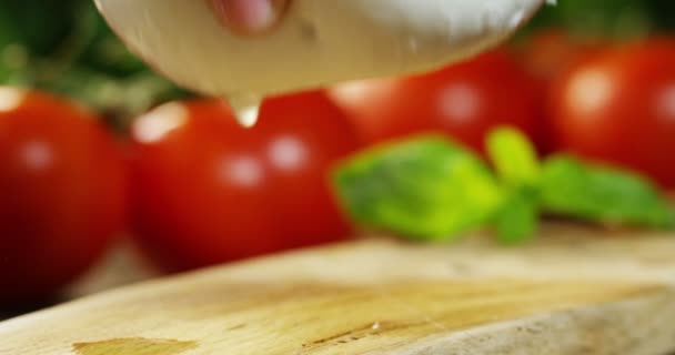 新鮮なイタリア Bufala とバイオ完全ミルクと背景の赤いトマトとバジルのマクロ撮影 新鮮なピザ イタリア料理 — ストック動画
