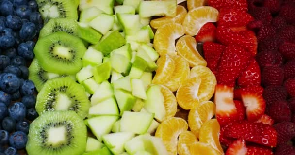 新鮮なフルーツは 合成は イチゴ リンゴ ブルーベリー ラズベリー キウイ オレンジをミックスします 夏に食べる新鮮なエキゾチックなトロピカル フルーツのサラダ — ストック動画