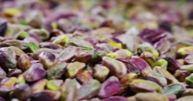 Adam dokunur renkli temizlenmiş fıstık, yeşil, mor, sarı. Kavram: 