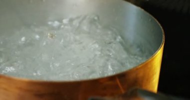 Profesyonel mutfak deneyimli bir aşçı İtalyan makarna tencerede su kabarcıkları yavaş süre pişirmek atar. Doğa, İtalya, gıda, diyet ve biyografi kavramı.
