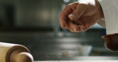 Profesyonel bir mutfakta deneyimli bir aşçı hamur işini İtalyan makarnası yapmak için unla hazırlar. Doğa, İtalya, gıda, diyet ve biyoloji kavramı.