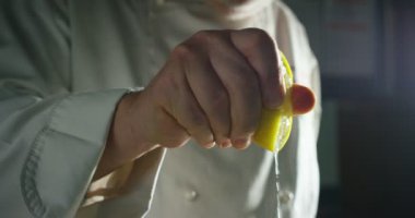 deneyimli şef aşçı aşırı yavaş çekimde renkli, hakiki bir limon sıkarak