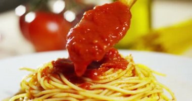 video kaşık sos ekleme üzerinde kırmızı domates soslu iştah açıcı pişmiş spagetti