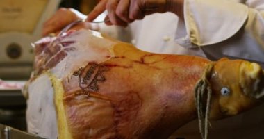 Genç uzman yardım İtalyan jambon bir kesim ile yavaş eski İtalyan geleneğe göre bıçak keser