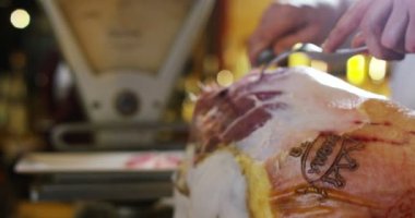 Genç uzman yardım İtalyan jambon bir kesim ile yavaş eski İtalyan geleneğe göre bıçak keser
