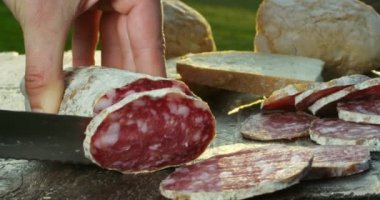 Profesyonel bir mutfakta deneyimli bir aşçı mevsimi keser. İtalyan salam sosisi çok ince dilimlerle profesyonel bir bıçakla kesilir. Doğa, İtalya, gıda, diyet ve biyoloji kavramı.