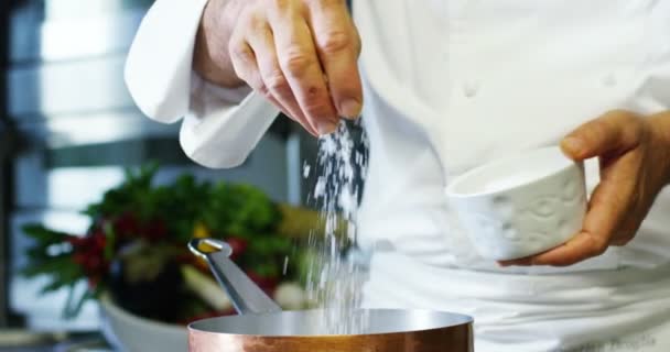 在意大利的专业厨房厨师倒盐放到盘子里或在水中煮意大利面食概念的健康和清淡的食物 — 图库视频影像