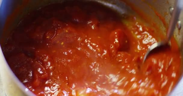 プロのキッチンでシェフは 木製のスプーンで赤いトマトのソースを混ぜます コンセプト ダイエット イタリア料理 — ストック動画