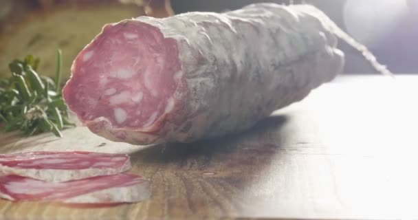 プロのキッチンで経験豊富なシェフが季節を切り取ります イタリアのサラミソーセージは 非常に薄いスライスを持つプロのナイフでカットされています イタリア 食べ物 生物の概念は — ストック動画