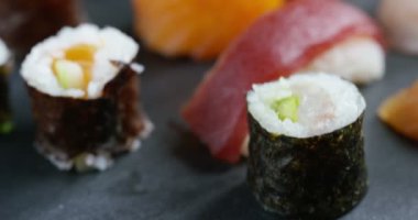 Makro çekim sushi, sashimi, uramaki ve nighiri. pirinç, somon veya ton balığı, karides ve balık yumurta oluşan tipik Japon çanak soya batırılmış. Konsept: Japon Restoran, sushi, oryantal gelenek.