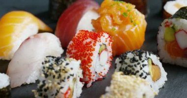 Makro çekim sushi, sashimi, uramaki ve nighiri. pirinç, somon veya ton balığı, karides ve balık yumurta oluşan tipik Japon çanak soya batırılmış. Konsept: Japon Restoran, sushi, oryantal gelenek.