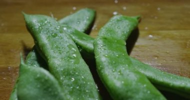 Makro yakın çekim kaymak taze sulu ıslak bezelye/fasulye ahşap mutfak masasında